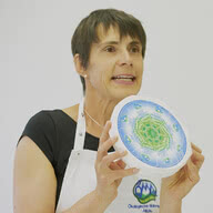 The image features a woman cradling a piece of our handcrafted Allgäu organic cheese, sharing her enthusiasm for its rich flavor and traditional provenance.
