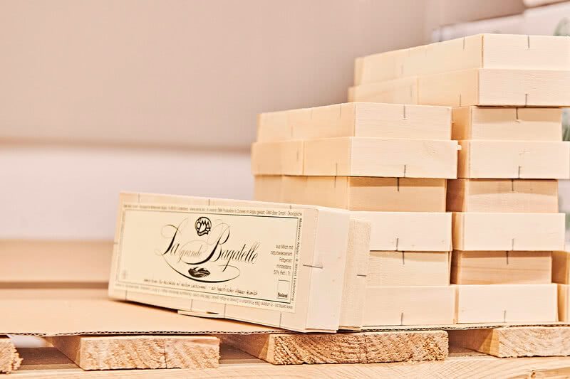 The image displays tidy stacks of wooden blocks alongside a package labelled ‘La grande Bagatelle’.
