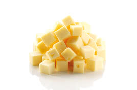 The image presents a pile of golden organic cheese cubes, crafted with care in the Allgäu region.