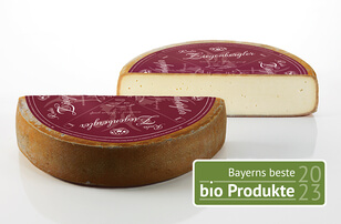 The image presents a piece of cheese bearing a label that identifies it as an organic product from Bavaria.